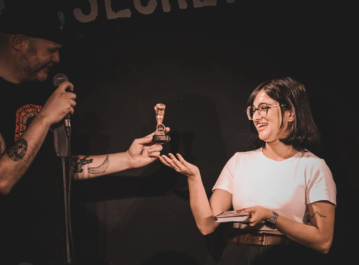 A Roast Battle competitor receiving a trophy
