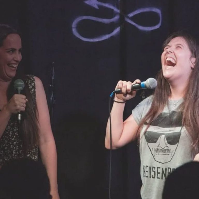 Two comedians laughing together on the Roast Battle stage